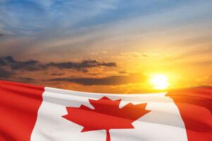 A Canada flag waves under the sunset